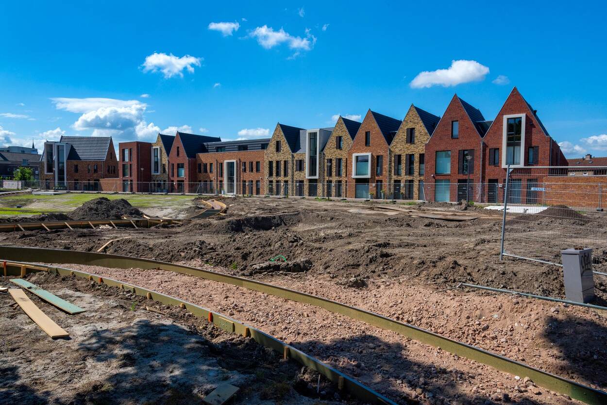 Foto van nieuwbouwhuizen met daarvoor nog braakliggend bouwterrein